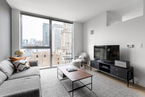 a living room with a couch and a tv at Loop 1BR w Gym Pool WD nr Millennium Park CHI-227 in Chicago
