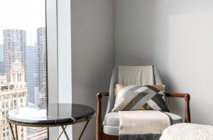 a glass table and a chair in a room with a window at Loop 1BR w Gym Pool WD nr Millennium Park CHI-227 in Chicago +38 photos