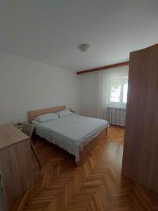 a bedroom with a bed and a wooden floor at Apartment in Njivice/Insel Krk 33552 in Njivice