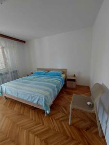 a bedroom with a bed and a chair in it at Apartment in Njivice/Insel Krk 33552 in Njivice