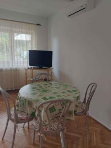 a dining room with a table and chairs and a television at Apartment in Njivice/Insel Krk 33552 in Njivice
