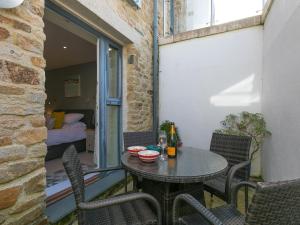 a patio with a table and chairs on a balcony at Golden Sands in St Ives