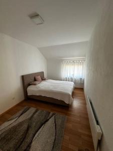 a bedroom with a bed in a white room at Milincic‘s 2 Zimmerwohnung in Banja Luka +3 photos