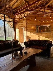 a living room with a leather couch and a wooden table at Bedouin Forest Residence in Valevtsi