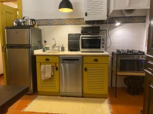 une cuisine avec des appareils en jaune et en argent dans l'établissement Casa da Galega, à Golegã