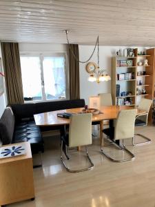 uma sala de jantar com uma mesa de madeira e cadeiras em Ferienwohnung am Tor zum Berner Oberland em Steffisburg