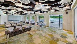 a dining room with tables and chairs and windows at The Nai Harn in Nai Harn Beach