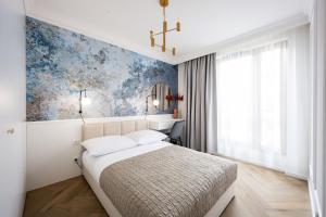 a bedroom with a bed and a blue wall at Native Apartments Orawska 14/127 in Krakow