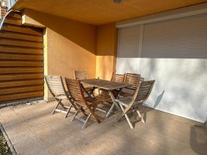 einen Holztisch und Stühle auf einer Terrasse in der Unterkunft Beachfront Apartment with garden in Csopak in Csopak