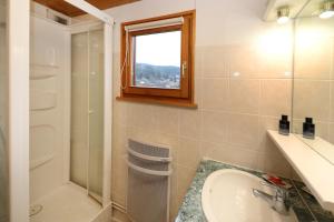 a bathroom with a sink and a shower and a sink at Le Chalet du Lac - Dans un environnement idéal in Xonrupt-Longemer