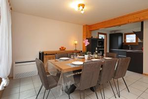 een eetkamer met een houten tafel en stoelen bij Le Chalet du Lac - Dans un environnement idéal in Xonrupt-Longemer