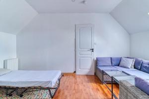 een woonkamer met een bank en een bed bij Les Nénuphars - Piscine et salle de sport équipée in Duinkerke