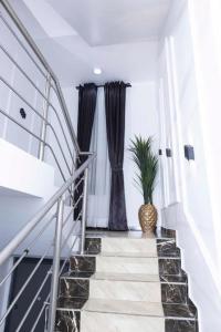 un escalier avec des rideaux noirs et une plante en pot dans l'établissement 3 bedrooms terrace at Osapa, à Lagos