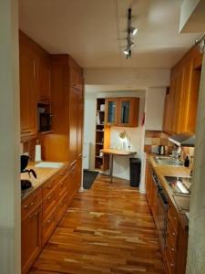 a kitchen with wooden cabinets and a wooden floor at Central Cozy 2BDR Getaway Sauna Free Park + Wi-Fi in Helsinki