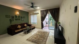 Desaru Homestay Southern, Tiara Desaru Seaview Residensi في Bandar Penawar: غرفة معيشة مع أريكة ونافذة