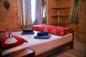 SheferにあるThe Edge Of The Village - Sheferの赤と青の枕が備わるドミトリールームのベッド1台分です。