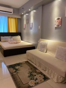 1 dormitorio con 2 camas y sofá en Sea Residences, en Manila