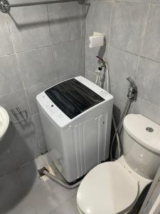 a bathroom with a toilet and a sink at Sea Residences in Manila