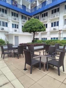 a group of chairs and tables in front of a building at Sea Residences in Manila