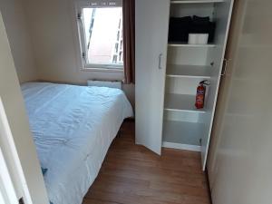 a small bedroom with a bed and a window at tiny house nabij de kust in Dirkshorn