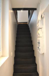 een trap in een huis met zwarte trappen bij Charming Apartment In Boulogne in Boulogne-Billancourt
