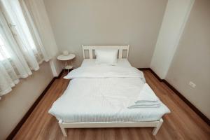 un letto bianco in una piccola stanza con finestra di Sage Bloom Retreat: 3BR Oasis Apartment a Il Cairo