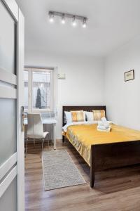 a bedroom with a large bed and a table at Zawady Comfort Apartment in Poznań