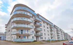 a white apartment building with a spiral at Zawady Comfort Apartment in Poznań