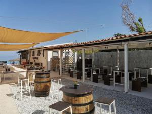 a patio with tables and chairs and a building at Zambrone Mare Appartamento / Piscina / Mare in Zambrone