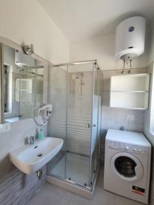 a bathroom with a sink and a washing machine at Zambrone Mare Appartamento / Piscina / Mare in Zambrone