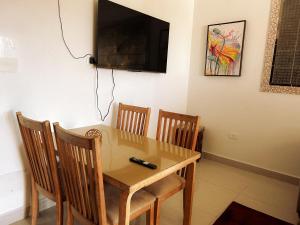 a dining room table with chairs and a television on the wall at Hammam Antistress in Sousse