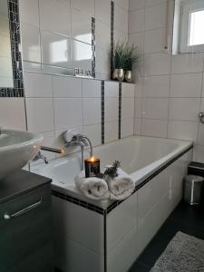 bagno con vasca, candele e asciugamani di Geräumige schöne Ferienwohnung stadtnah ruhig Nähe Bodensee mit Aussicht a Weingarten