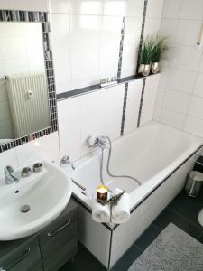 a bathroom with a sink and a bath tub and a sink at Schöne große Ferienwohnung BASILIKABLICK stadtnah ruhig Nähe Bodensee mit Aussicht in Weingarten +11 photos