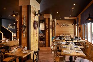 a restaurant with wooden tables and chairs in a room at Hôtel L'Arboisie in Megève