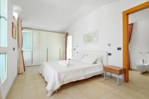 Habitación blanca con cama y lavabo en Villa Marconi Apartment 12 attico, en Golfo Aranci