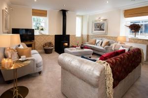 a living room with two couches and a fireplace at Dryburgh Steading One in Saint Boswells