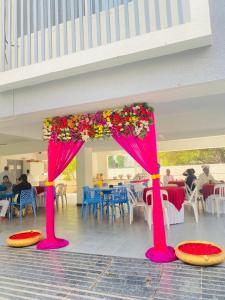 un escenario rosa con flores en un restaurante en 9 Bedroom Villa with Open Garden ALL ROOMS ATTACHED, en Pune