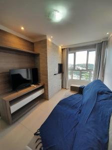 a bedroom with a large bed and a flat screen tv at Apê BENTO com churrasqueira! in Bento Gonçalves