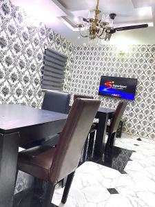 a dining room with a table with a laptop on it at DIVINE VILLA AND RESORTS HOTEL GUEST House 15 mins Near Michael Okpara University Sam Mbakwe Airport in Umuhu