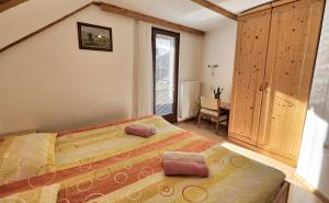 a bedroom with a bed with two pillows on it at Apartmaji JOŠT in Bohinj