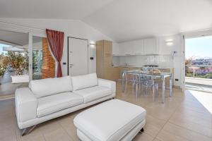 sala de estar con sofá blanco y cocina en Villa Marconi Apartment 12a attico, en Golfo Aranci