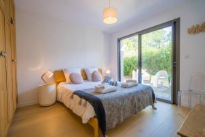 um quarto com uma cama e uma grande janela em Pyla Belle villa au calme Proche plage em Pyla-sur-Mer