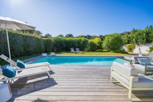 uma piscina com duas cadeiras e um guarda-sol em Pyla Belle villa au calme Proche plage em Pyla-sur-Mer