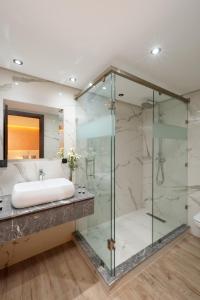 a bathroom with a glass shower and a sink at SWISS CONTINENTAL HOTEL Free Cooking Classes in Marrakech