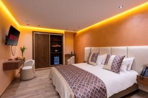 马拉喀什Swiss Continental Hôtel的一间配有床和电视的酒店房间