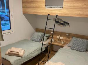 een kamer met 2 stapelbedden en een ladder bij Oliva Mobile Home in Biograd na Moru