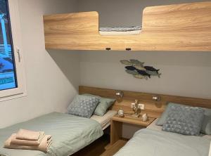 twee bedden in een kleine kamer met ermottermottermott bij Oliva Mobile Home in Biograd na Moru