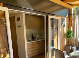 een keuken met een glazen schuifdeur naar een patio bij Oliva Mobile Home in Biograd na Moru