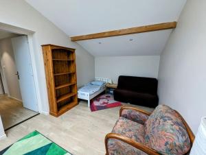 ein Wohnzimmer mit einem Sofa und einem Stuhl in der Unterkunft Pastisse YourHostHelper in Anglet