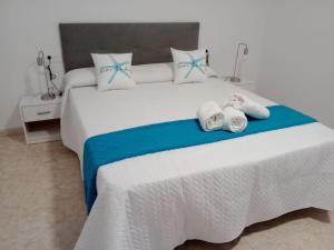 a bedroom with a large white bed with towels on it at Paraíso Azul in Aguadulce +60 photos